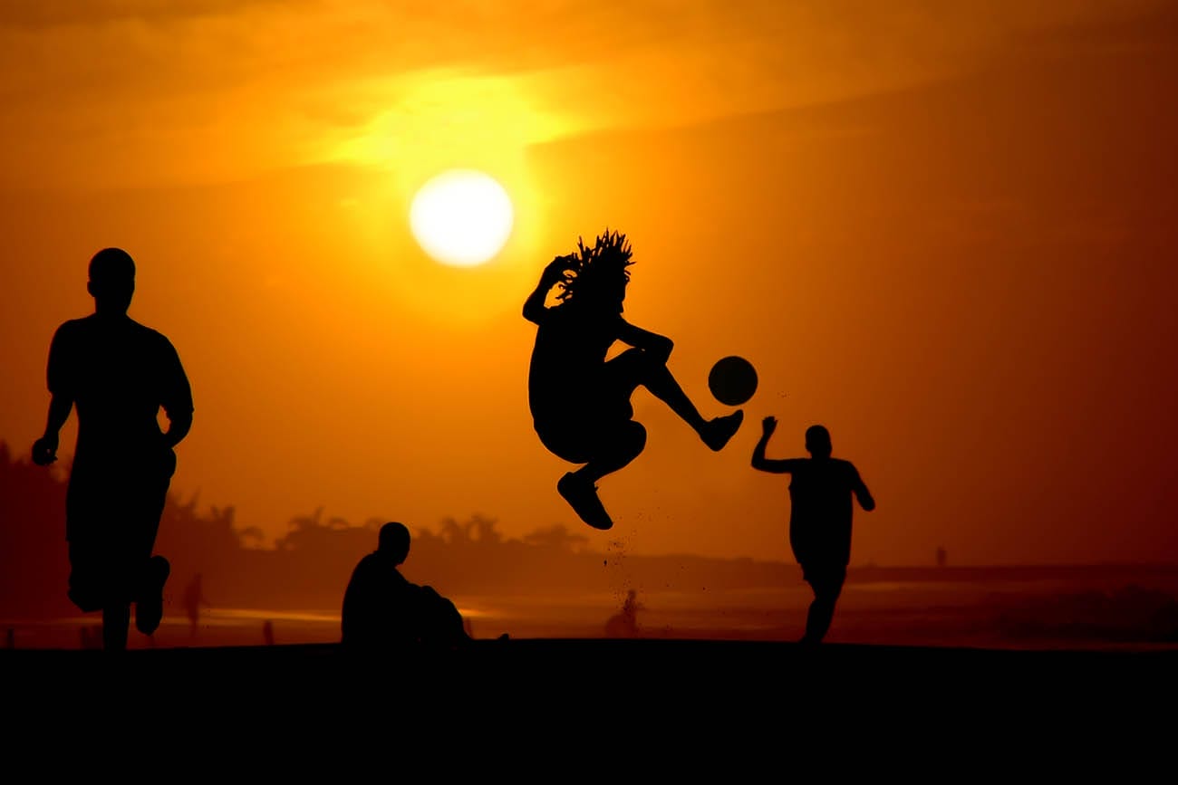 Playing football at the sunset on the beach