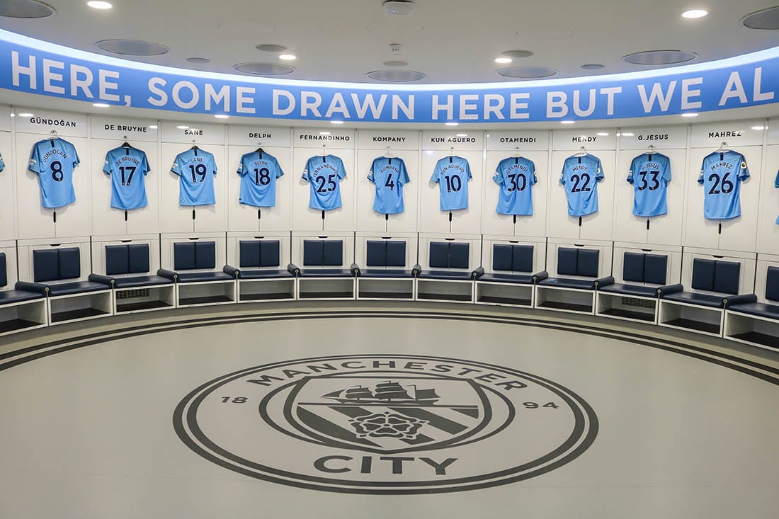 MANCHESTER - ENGLAND, MAY 16, 2019 : Player's jerseys hung in front of lockers in the changing room at Etihad Stadium; the home ground of Manchester City Football Club.