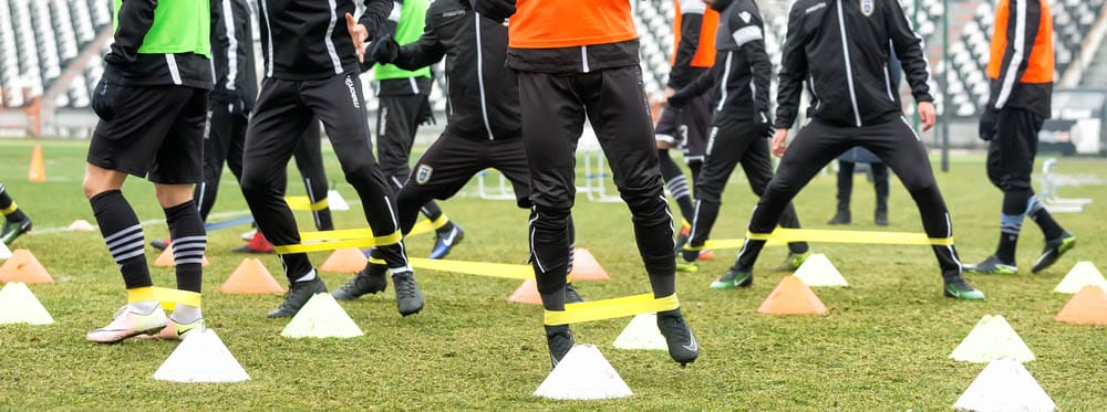 The feet of PAOK players and football training equipment during the training of the team on the pitch Toumba.