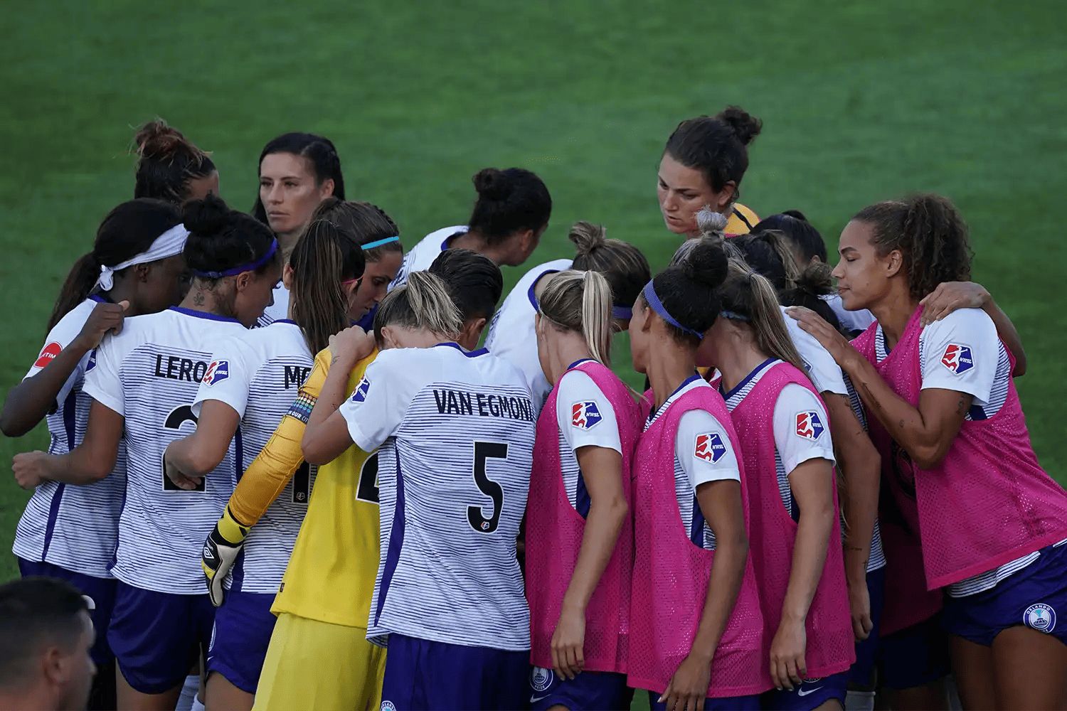 a women's football team in a huddle